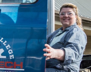 A diesel tech student smiles as she opens the door to a Centralia College truck.